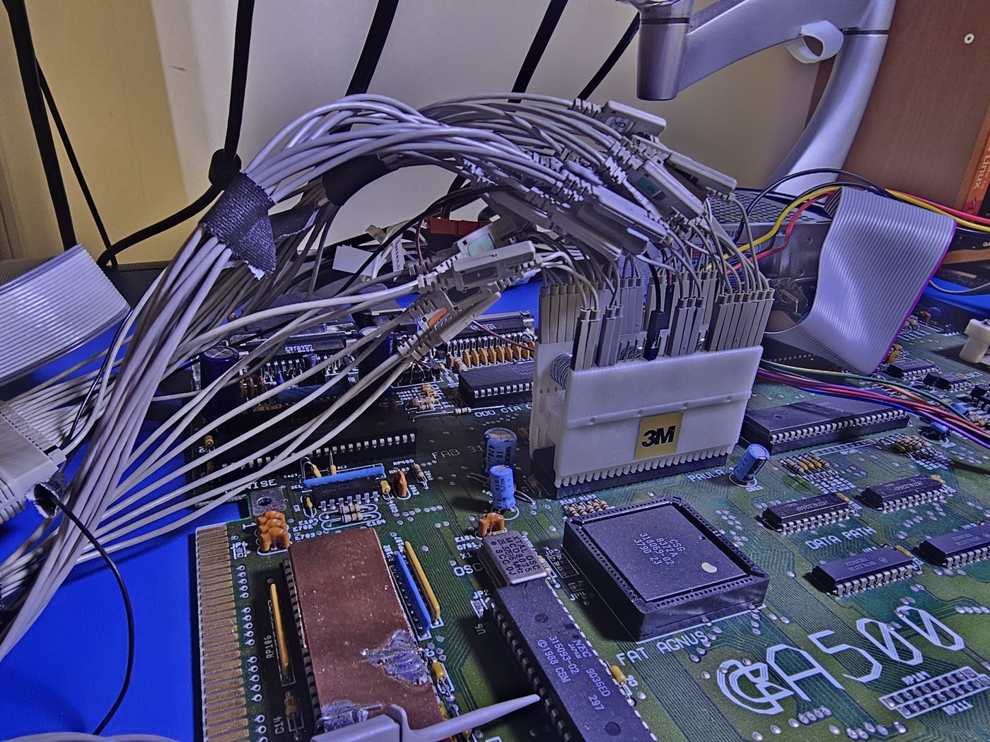 Closeup of a 3M DIP clip fitted over Paula on an Amiga 500 motherboard, with individual logic analyzer probes attached to its contacts